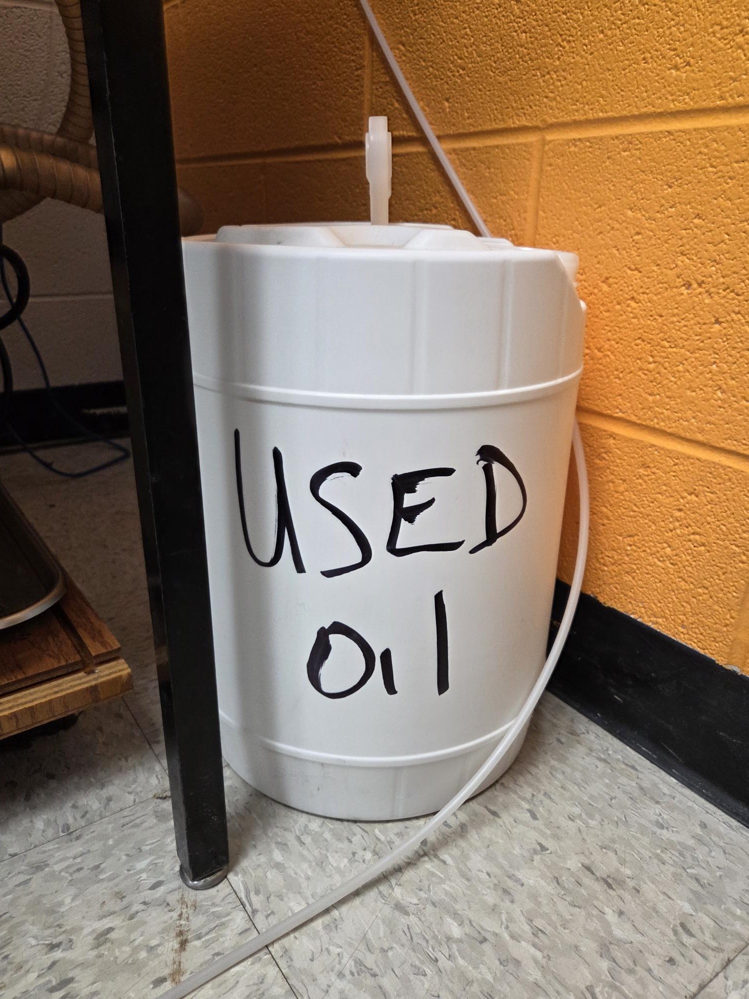 5-gallon container with words “Used Oil” on the side.
